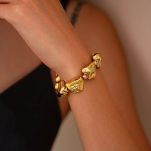 Primer plano de pulsera dorada con cuentas CCB irregulares y textura de metal fundido