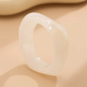 Detailed view of wide translucent cream resin ring with subtle marble texture