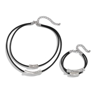 Detail of layered black leather cord necklaces and bracelets with silver metal tubes