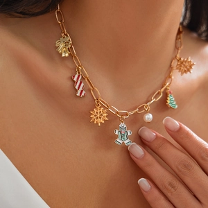 Primo piano della collana natalizia dorata con ciondoli a forma di omino di pan di zenzero