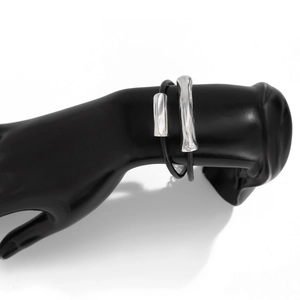 Detailed view of silver metal bangles with black straps on a black hand mannequin