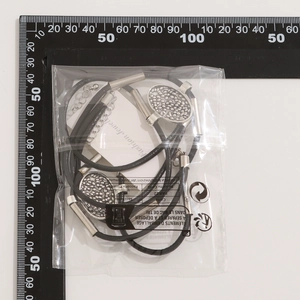Detail view of multi-layer wax cord necklace set with silver cylinders in packaging