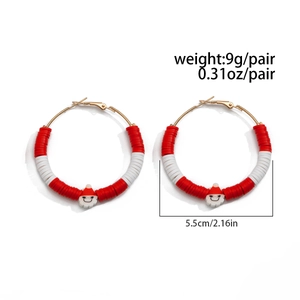 Detailed view of Christmas hoop earrings with red beads and Santa Claus charms