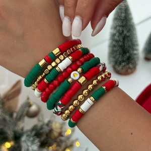 Gros plan d'un ensemble de bracelets de Noël avec perles heishi rouges et vertes