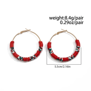 Detail view of 5.5cm gold hoop earrings featuring red white and green heishi clay beads