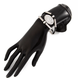 Detail of multi-strand black cord bracelet with textured silver metal charms on a hand model