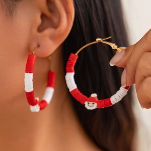 Christmas hoop earrings with red and white clay beads and a small Santa Claus charm
