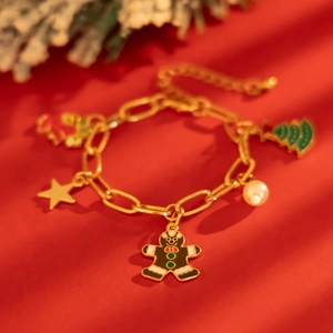 Dettaglio del bracciale natalizio dorato con omino di pan di zenzero e ciondoli smaltati su rosso
