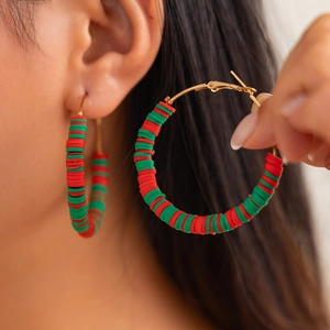 Close-up of handmade red and green polymer clay hoop earrings for Christmas gifts