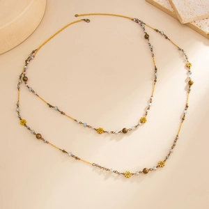 Detail of Bohemian long beaded chain with golden flowers and vintage crystal beads