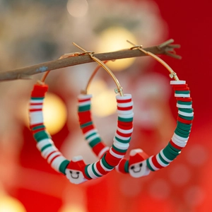 Detail view of festive Christmas hoop earrings with colorful heishi beads and Santa charms