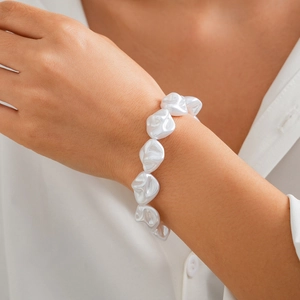 Detailansicht eines barocken Perlenarmbands mit unregelmäßiger Textur auf Seidenmanschette