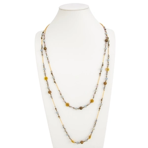 Detail of bohemian layered necklace with blue beads and gold flower pendants
