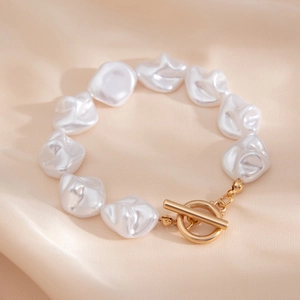 Barockperlen-Armband mit goldenem OT-Knebelverschluss auf luxuriöser Champagnerseide