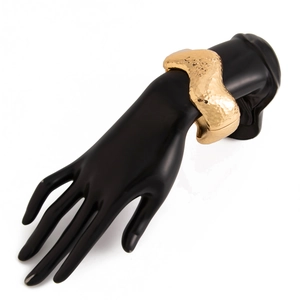 Detailed view of wide golden bracelet with liquid metal hammered texture and wave design