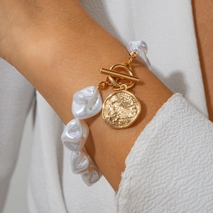 Nahaufnahme von Barockperlenarmband mit goldener OT-Schließe und gehämmerter Münze