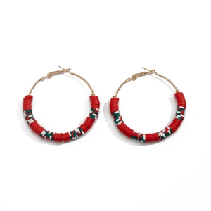 Detail of festive Christmas hoop earrings with red, green and white clay beads on gold rings