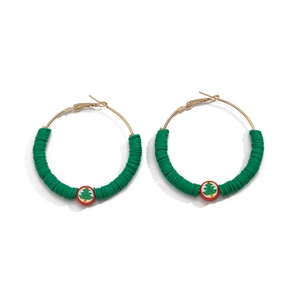 Macro view of Christmas earrings with green clay beads and red Santa tree pattern