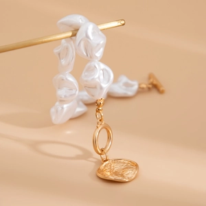 Makroaufnahme der Barockperlenkette mit goldenem OT-Verschluss und strukturiertem Anhänger