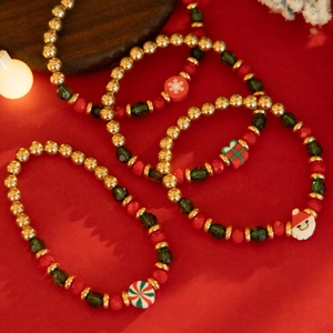 Detailed view of Christmas beaded bracelets with snowman and reindeer charms on red background