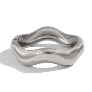Polished silver wave bangle with irregular spring design and metallic mirror finish