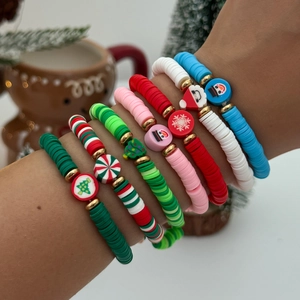 Bracelets de Noël en perles d'argile avec breloques portés sur le poignet