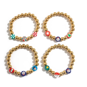 Detail of four golden beaded Christmas bracelets with festive charms and colorful holiday motifs