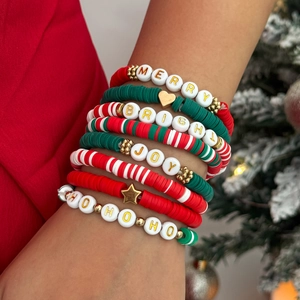 Détail de bracelets de Noël en perles Heishi avec lettrage MERRY et JOY au poignet