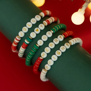 Macro detail of Christmas beaded bracelets with Jolly and Merry lettering charms