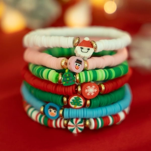 Détail des bracelets de Noël en argile polymère avec breloques Père Noël et flocons