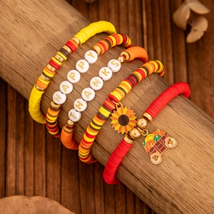 Detail von handgemachten Erntedankfest-Armbändern mit Kürbis- und Sonnenblumenanhängern