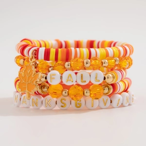 Close-up of Fall beaded bracelet set with orange maple leaf charm and letter beads
