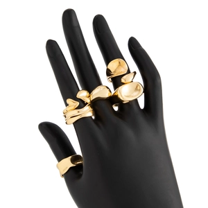 Detail of three liquid gold irregular alloy rings on a hand model with polished finish