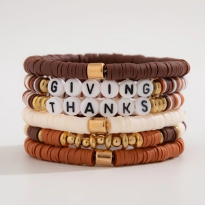 Detail of GIVING THANKS layered Heishi bead bracelets with gold accents in earth tones