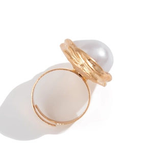 Détail d'une bague perle baroque avec texture martelée dorée et anneau ouvert réglable