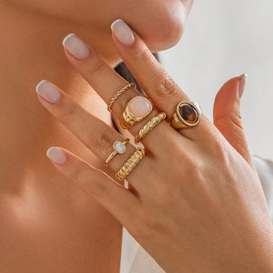 Set aus 6 goldenen Ringen mit rosa Edelstein und Opal-Details an Modelhänden