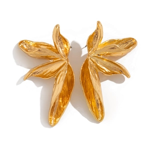 Detailopname van gouden ginkgo blad oorbellen met een gehamerde metalen textuur