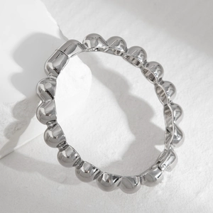 Macro shot of silver metal bubble bracelet showing 3D round spheres and polished texture