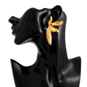 Detailweergave van grote gouden vintage bladoorbellen op een zwarte displaybust