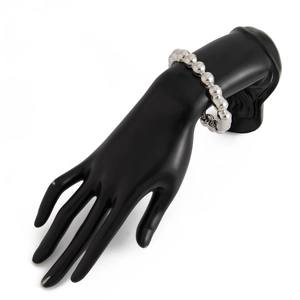 Close-up of polished silver metal bead bracelet on a black hand display stand