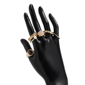 Detailansicht eines fünfteiligen Goldring-Sets mit bunten Edelsteinen auf schwarzem Handmodell