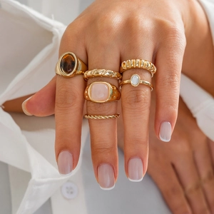 6er-Set goldene Bohemian-Ringe mit Bernstein- und rosa Steinen an einer Frauenhand