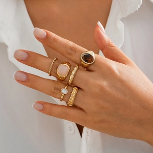 6-teiliges goldenes Ring-Set mit rosa und bernsteinfarbenen Edelsteinen an der Hand