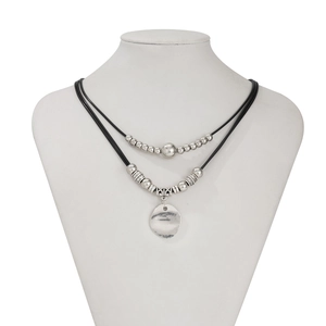 Detail view of double-layer retro necklace with black cord, metal beads and round pendant