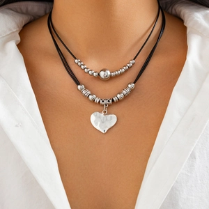 Double-layer bohemian necklace featuring silver heart pendant and beads on black wax cord