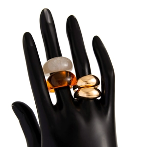 Moderne ringenset van goud metaal en amberkleurige hars op een zwart handmodel
