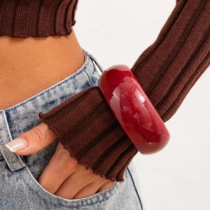 Detail of wine red translucent resin bangle featuring natural marble texture on wrist
