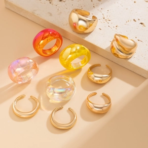 Platte weergave van hars en gouden ringen op stenen basis met diverse kleuren en texturen