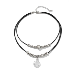 Detail of layered black wax cord necklace with silver beads and baroque pearl pendant