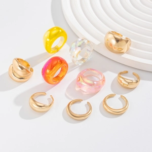 Detail van 10-delige goudkleurige legering en amberhars ringenset op wit display